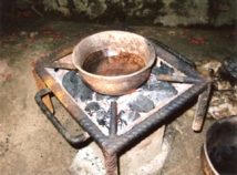 Canari tsinzu sur un foyer moderne, photographié dans la cour de son épouse par M. Albert Bassoumba, Brazzaville, quartier du grand séminaire du Djoué, mai 2011. C'est avec le tsinzu qu'on prépare le meilleur bibété ou pâte de graines de courge. On remarquera le décor très particulier de cette céramique, obtenu à partir de feuilles d'arbres appliquées sur le vase avant  cuisson qui donnent ces motifs ocellés aléatoires, spécialité des potiers de Manzakala près de Nkankata.